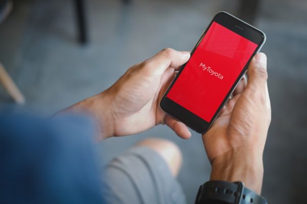 A owner using the MyToyota app to check the battery level of the car 